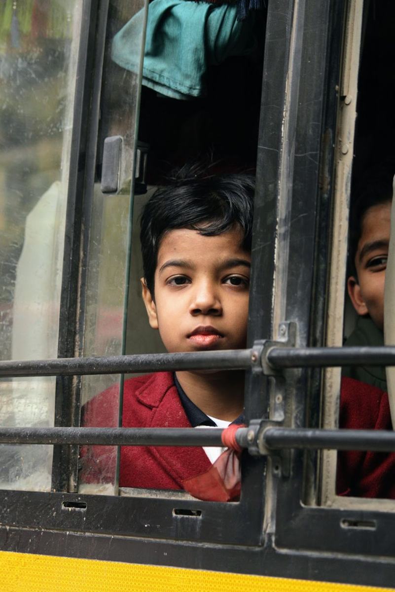 A student looking out of the school bus window