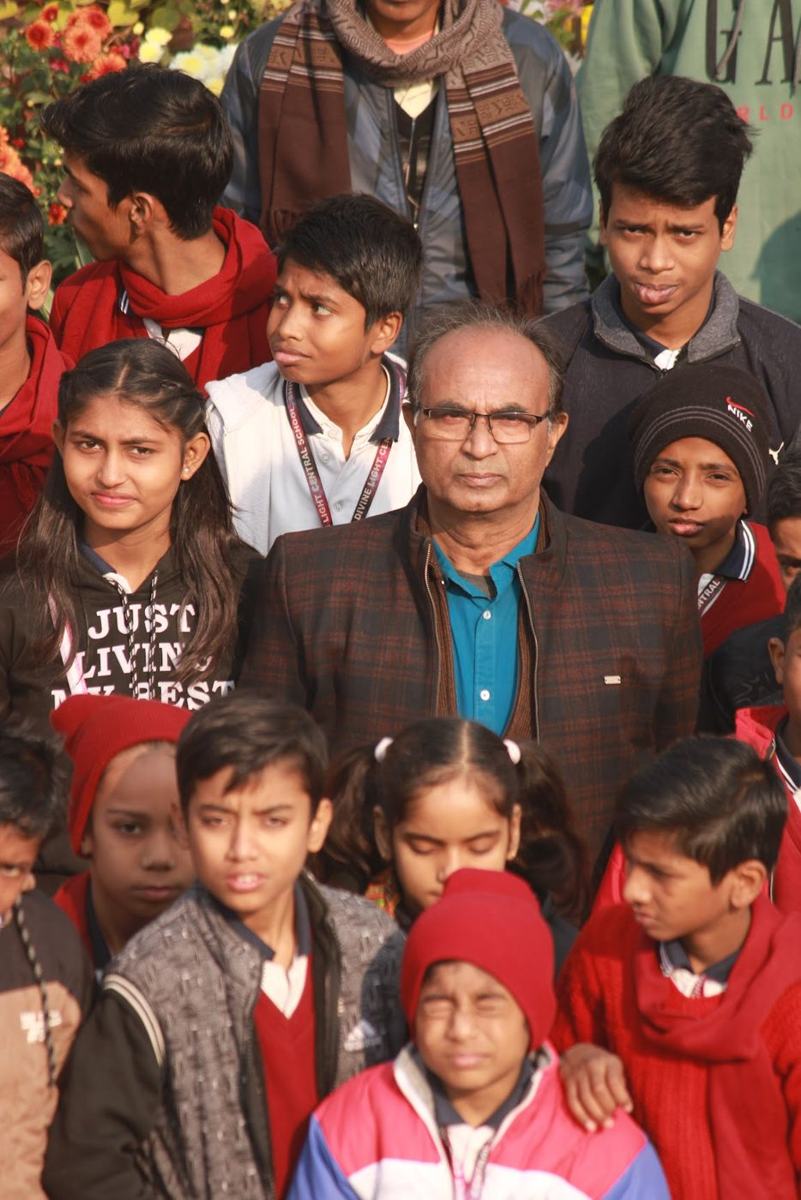 The director standing among students on an outing