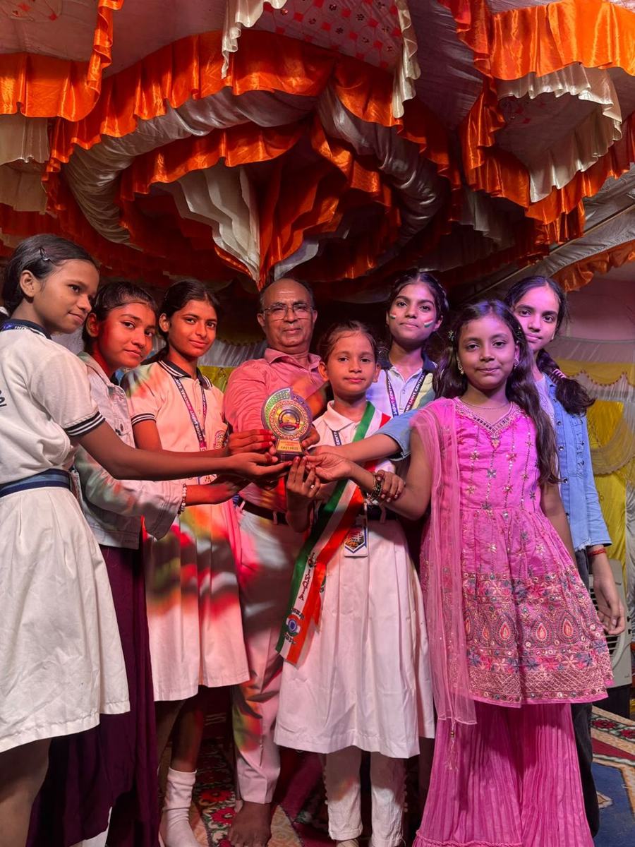 Students holding a first prize trophy with the director